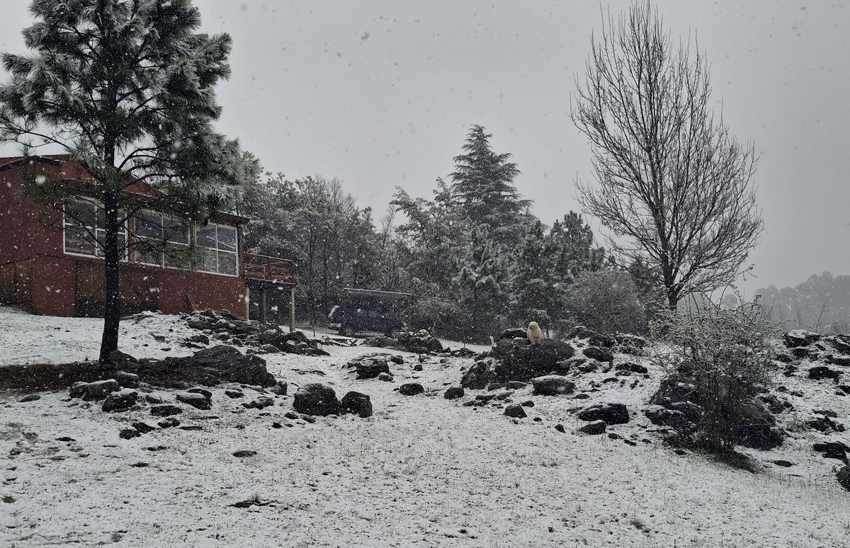 Cabaña Roja con su quincho vidriado rodeada de nieve en Villa Yacanto