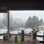 Mesa con mate en el quincho vidriado de la Cabaña Roja, con vista al complejo nevado