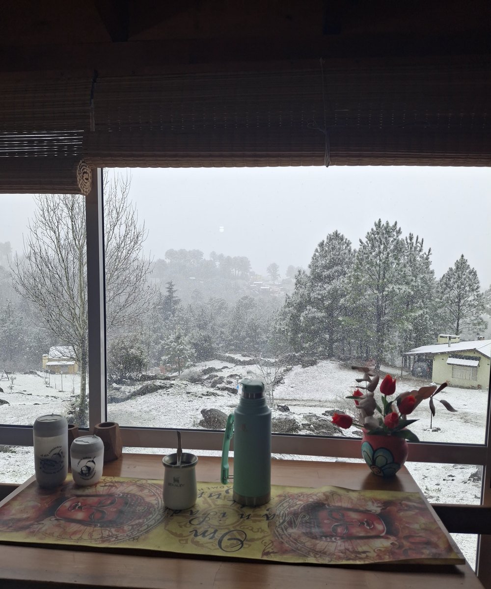 Mesa con mate en el quincho vidriado de la Cabaña Roja, con vista al complejo nevado
